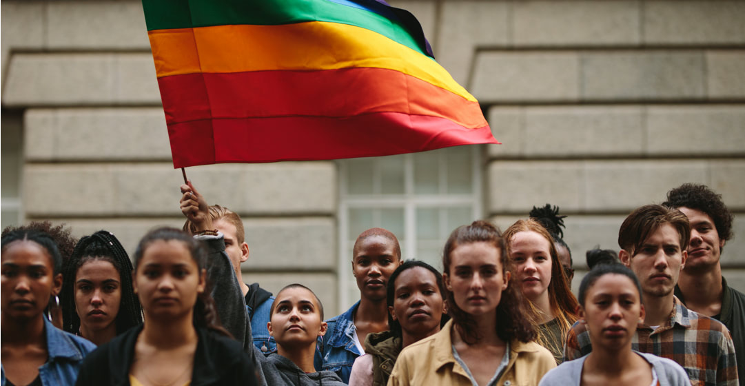Grupo de gente ondeando una bandera LGBTQI+