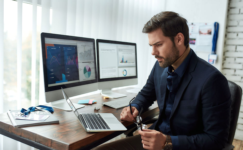 Hombre concentrado realizando análisis financiero empresa despacho